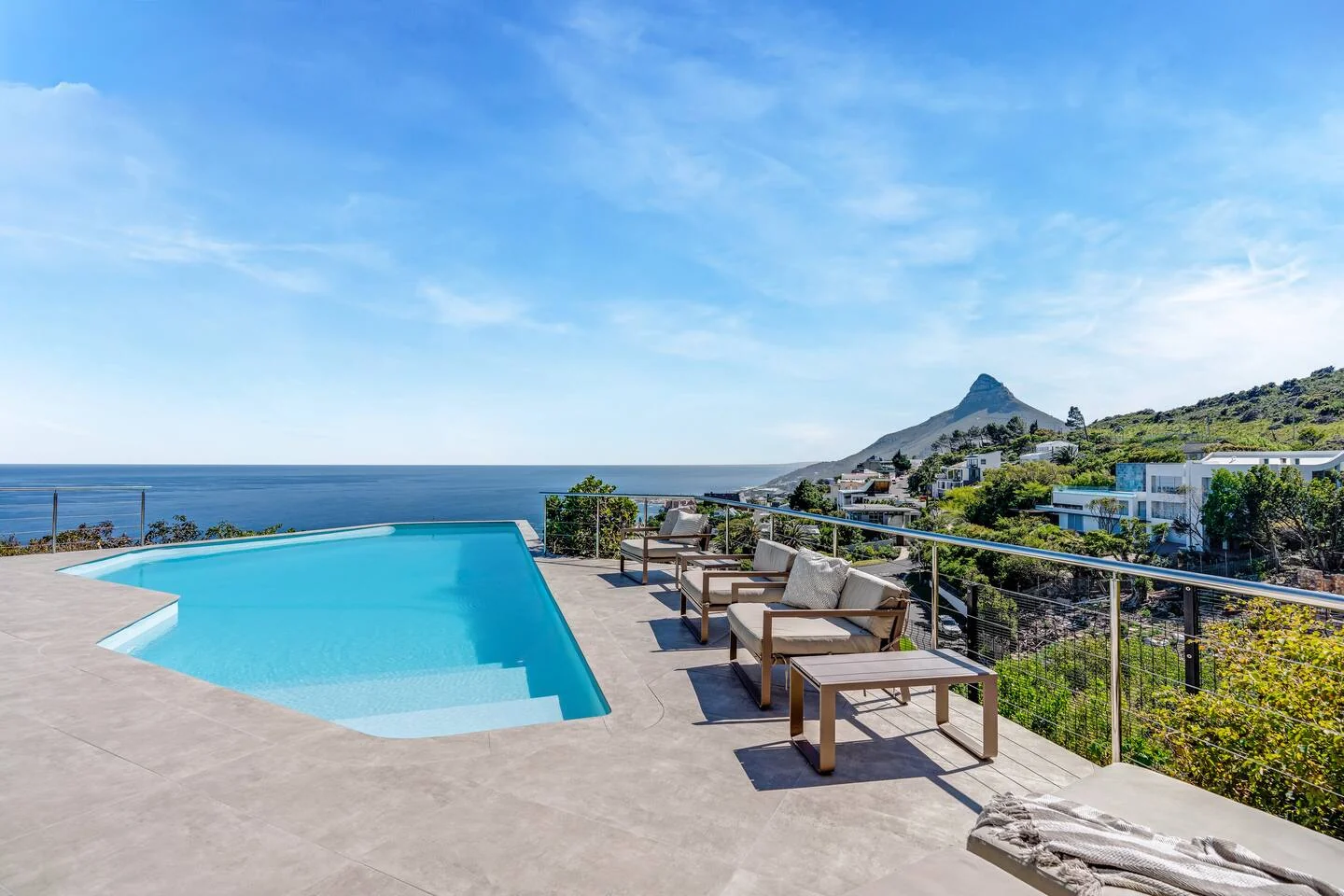 Wide infinity pool and furnished terrace overlooking the Atlantic toward Lion's Head