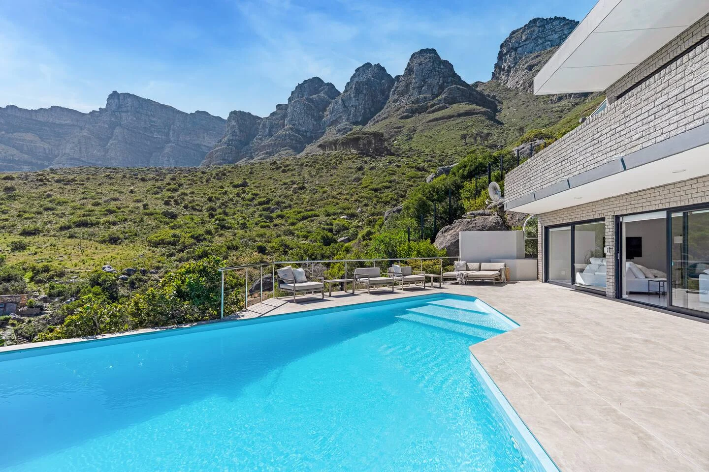 Infinity pool framed by the villa and the Twelve Apostles mountain slope