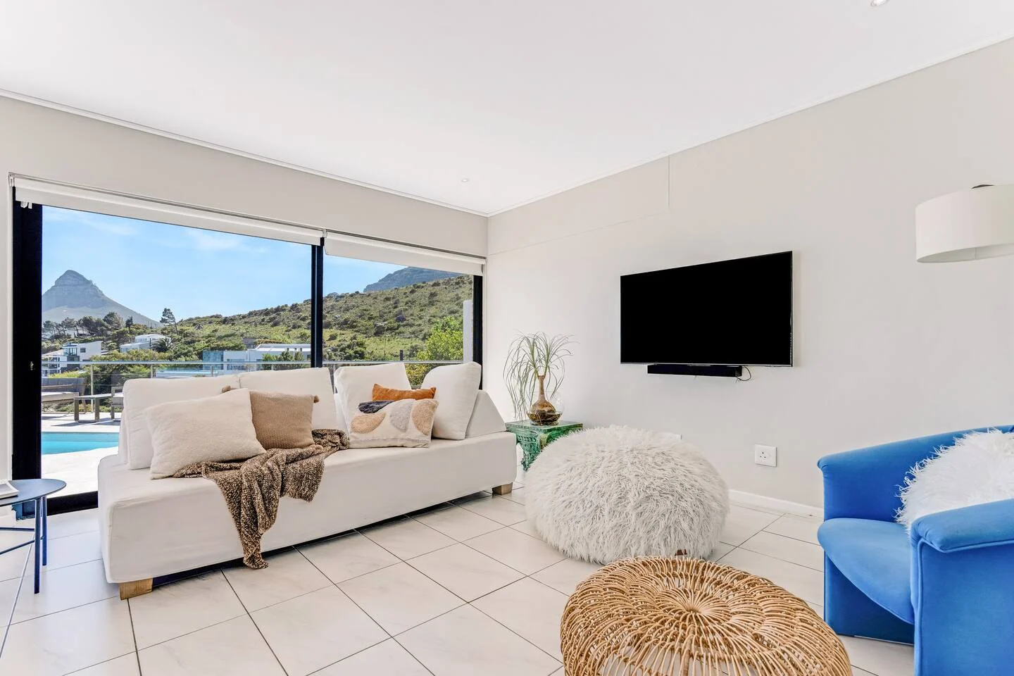 Lounge seating and broad glazing opening toward the pool and mountain